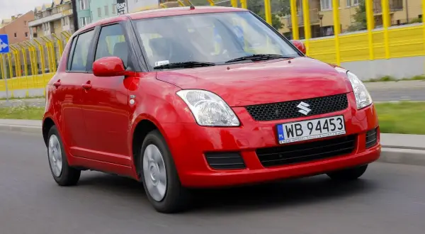 Czerwony Suzuki Swift 2008 na drodze, z widocznymi tablicami rejestracyjnymi WB 94453.