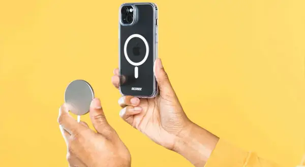 Découvrez magsafe c'est quoi : un chargeur rond magnétique se fixe à l'arrière d'un iPhone dans une coque transparente.
