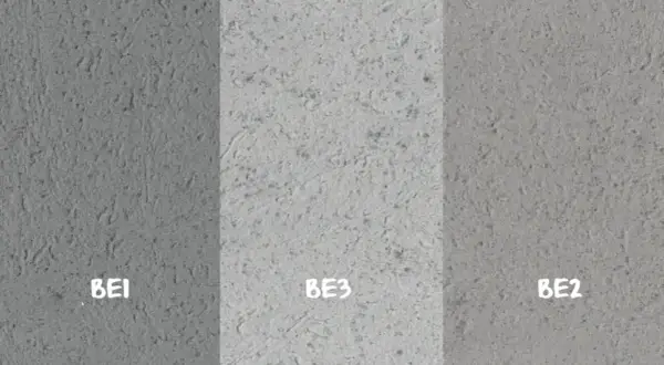 Próbki betonu dekoracyjnego na ścianę: BE1 (ciemniejszy), BE3 (jasny), BE2 (średni). Różne tekstury i odcienie szarości.