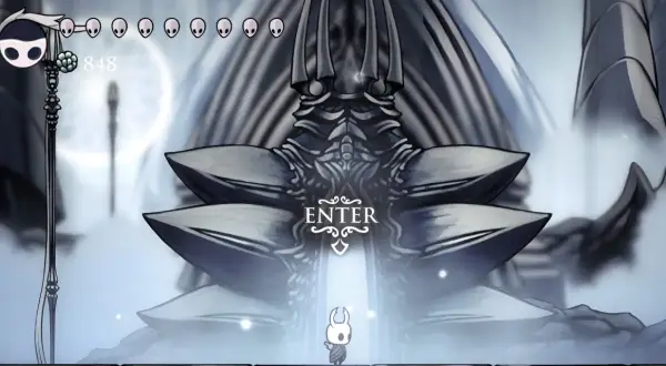 Mały rycerz stoi przed monumentalną bramą w White Palace Hollow Knight.