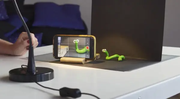 Tworzenie zielonych robaczków do animacji poklatkowej. Telefon nagrywa, ręka reguluje lampę.