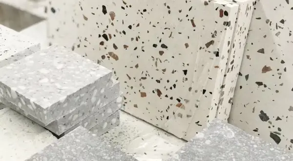 Stosy płyt z lastryka w odcieniach szarości i bieli, z widocznymi fragmentami kamieni.