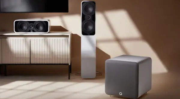 Różne rodzaje kolumn: kompaktowa, podłogowa i subwoofer, tworzą stylowy zestaw audio w nowoczesnym wnętrzu.