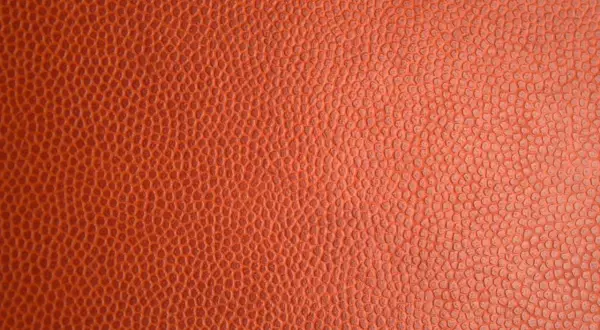 Texture d'un ballon de basket orange. Pour savoir si c'est du vrai cuir, observez la régularité des alvéoles.
