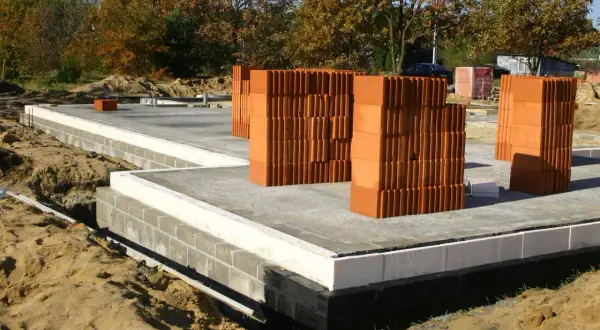 Budowa domu: betonowe płyty, bloczki, palety pustaków ceramicznych. Zastanawiasz się, ile kosztuje postawienie fundamentów?