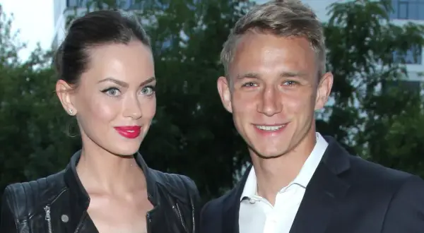 Edyta Zając i Jakub Rzeźniczak uśmiechają się do obiektywu. Ona w skórzanej ramonesce i z mocnym makijażem, on w eleganckim garniturze.