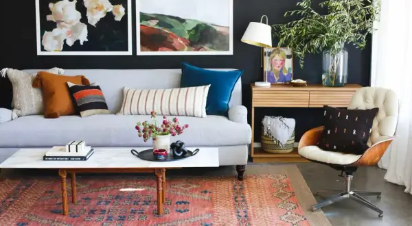 Ideas on how to decorate a coffee table: a marble-top table with books, a tray with flowers, and a decorative object.