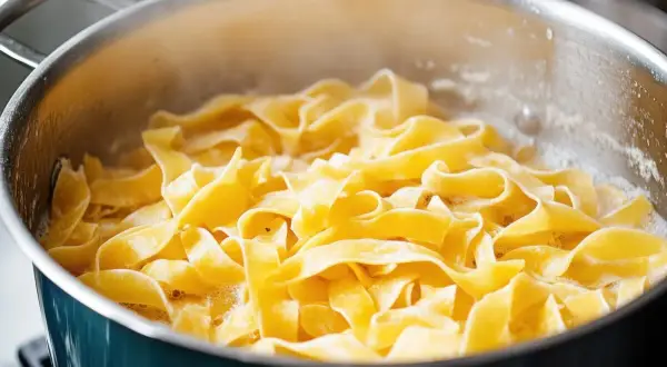 Sączący się z garnka gorący, świeży linguini, gotowy do podania z ulubionym sosem.