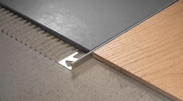 Le sol présente 2 carrelages différents : un gris moderne et un imitation bois chaleureux, séparés par une plinthe métallique.