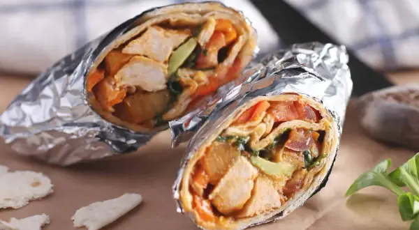 Två saftiga wraps med kyckling, avokado och grönsaker, perfekt för en paus på wärdshuset Klarälvdalen.