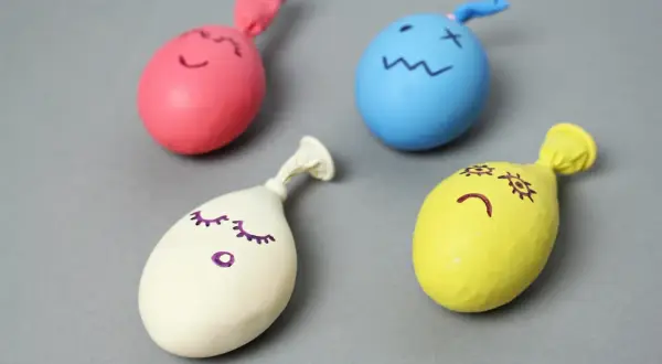 Kolorowe balony z narysowanymi buźkami – idealne, by pokazać, jak zrobić zabawki antystresowe.
