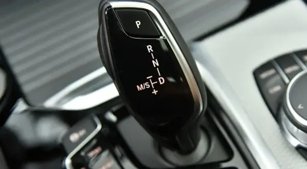 Dźwignia zmiany biegów w BMW G01. Widoczne oznaczenia P, R, N, D oraz M/S z możliwością ręcznej zmiany biegów.