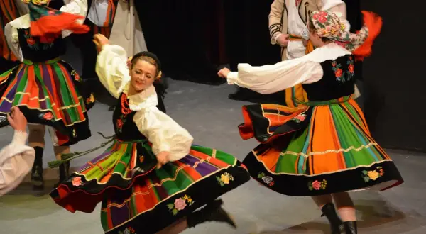 Tancerze w tradycyjnych polskich strojach ludowych wykonują taniec oberek.