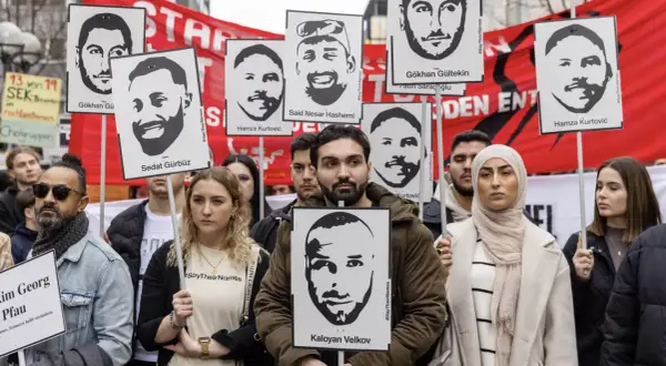 Menschen halten Porträts von Opfern des Hanau-Anschlags hoch. Die Namen der Ermordeten wie Gökhan Gürbüz und Kaloyan Velkov werden gezeigt.