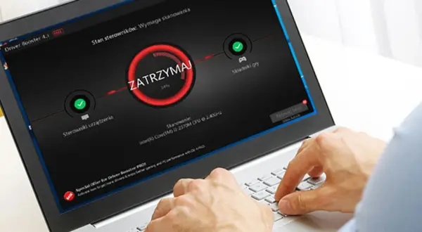 Użytkownik korzysta z laptopa z programem Driver Booster, który pomaga w aktualizacji sterowników, zapewniając płynniejsze działanie gier i komputera.