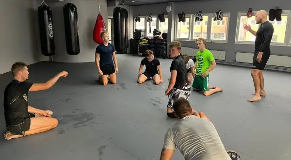 Tränare instruerar unga atleter i en gymlokal i Sverige. Kanske förbereder de sig för sumobrottning Sverige.