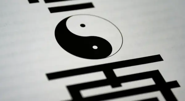 Symbol Yin Yang na białym tle, otoczony chińskimi znakami. Ilustruje różnicę między wiarą a wiedzą, perspektywę filozoficzną i teologiczną.