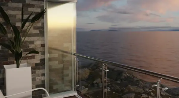 Balcone con vepa edilizia libera, vista mare al tramonto. Pianta in vaso e arredi moderni.