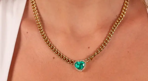 Collar de oro con colgante de corazón de esmeralda y diamantes. Un ejemplo de nombres de joyas que evocan elegancia y amor.