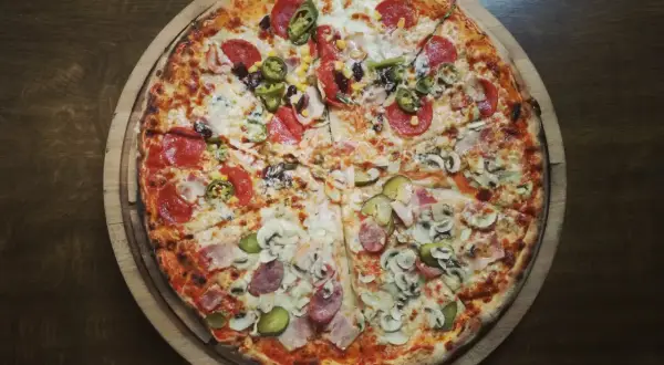 Apetyczna pizza z różnymi dodatkami. Zastanawiasz się, ile kalorii ma kawałek pizzy? Ta wygląda na sycącą!