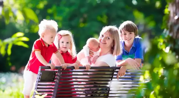 Szczęśliwa mama z czwórką dzieci, marząca o emeryturze dla matek 4 dzieci, które pracowały.