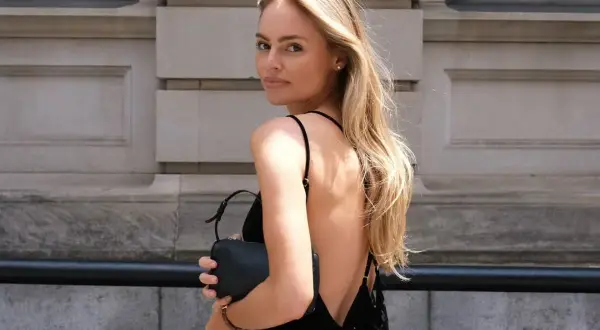 Blondynka w czarnej sukience bez pleców, idealna stylizacja. Zastanawiasz się, jaki biustonosz do sukienki bez pleców? Ten model jest doskonałym przykładem.