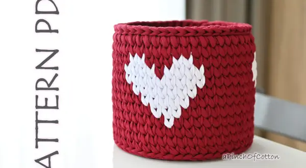 Cestino uncinetto rosso con cuori bianchi, perfetto per decorare la casa o come idea regalo.