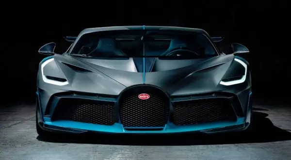 Szary Bugatti Divo z niebieskimi akcentami, przód samochodu na ciemnym tle.
