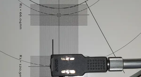Precyzyjna kalibracja wkładki gramofonowej Sony na szablonie z liniami i wymiarami.