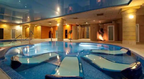 Piscina de hidromasaje con tumbonas integradas, ideal para relajantes sesiones de spa.