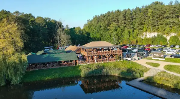 Drewniane restauracje nad wodą, pełne gości. Sprawdź pstrągowo menu cennik i zaplanuj wizytę.