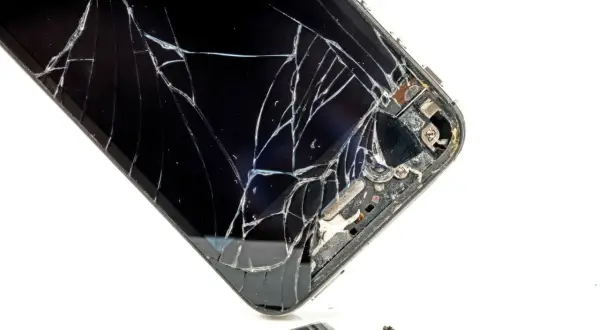 Rozbite szkło telefonu. Widać pęknięcia i fragmenty, które odpadły. To pokazuje, czym się różni szkło hartowane od hybrydowego w praktyce.