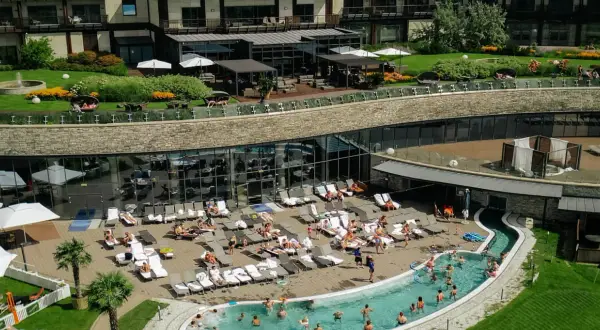 Hotel Arłamów ceny: relaks przy basenie i w spa. Widok z góry na basen, leżaki i zielony teren.