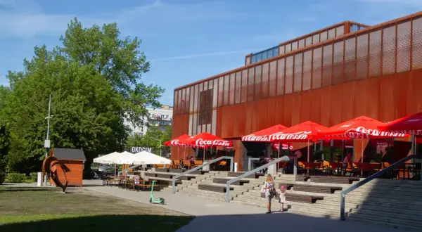 Kraków Klub Studio z czerwonymi parasolami Coca-Cola i schodami prowadzącymi do wejścia.