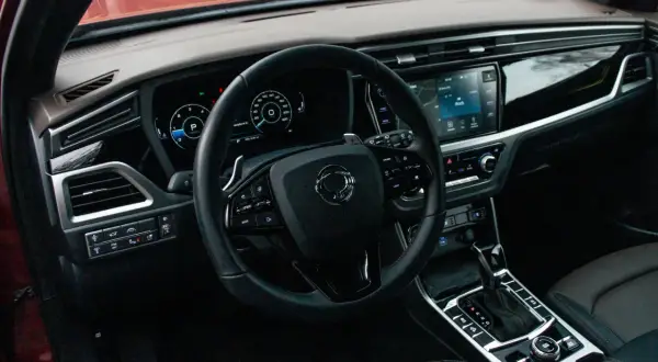 Wnętrze Ssangyong Korando, które często pojawia się w ssangyong korando - opinie użytkowników. Widoczna kierownica, ekran multimediów i panel sterowania.