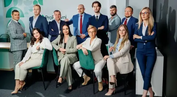 Grupa prawników w garniturach pozuje do zdjęcia w biurze.