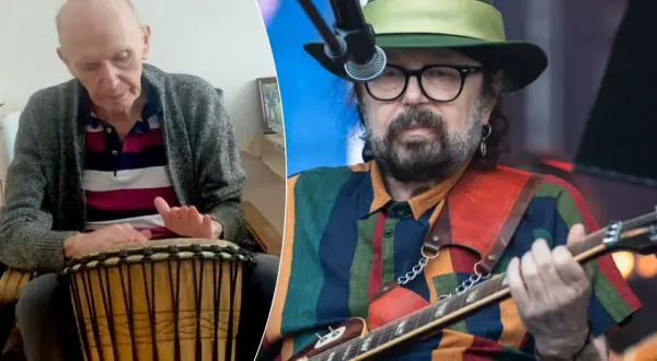 Starszy mężczyzna gra na bębnie, obok muzyk w kapeluszu z gitarą. Może to być perfect kołysanka dla nieznajomej tekst.