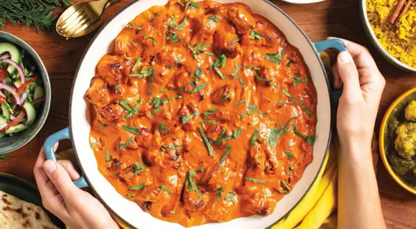 Pyszny butter chicken przepis w kremowym sosie, podany z ryżem, sałatką i chlebkiem naan.