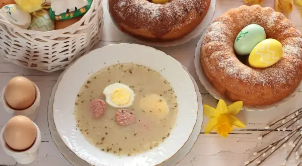 Tradycyjny barszcz chrzanowy z jajkiem i kiełbasą, babki drożdżowe, pisanki i koszyczek z kurczakiem tworzą świąteczny stół.