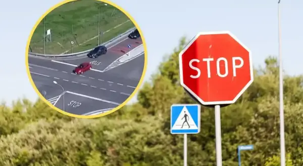 Czerwony samochód ignoruje znak STOP, ryzykując niezatrzymanie się na stopie. Obok znak przejścia dla pieszych.