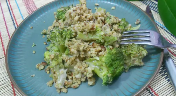 Un délicieux crumble brocolis aux noix, servi sur une assiette bleue.