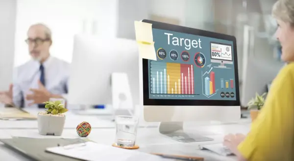 Kobieta analizuje wykresy na ekranie komputera, planując kampanię reklamową w internecie.