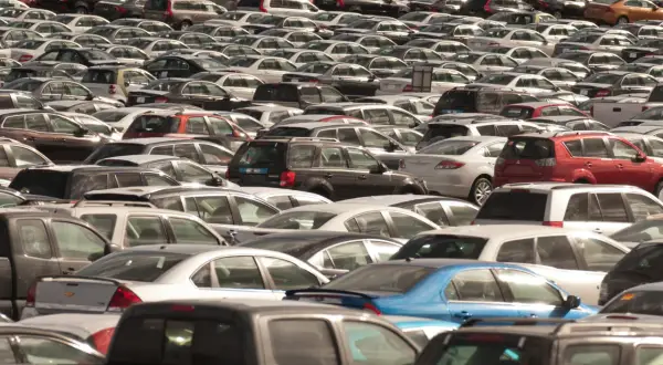 Ogromny parking pełen samochodów różnych marek. Widać wiele modeli, od sedanów po SUV-y, w różnych kolorach.