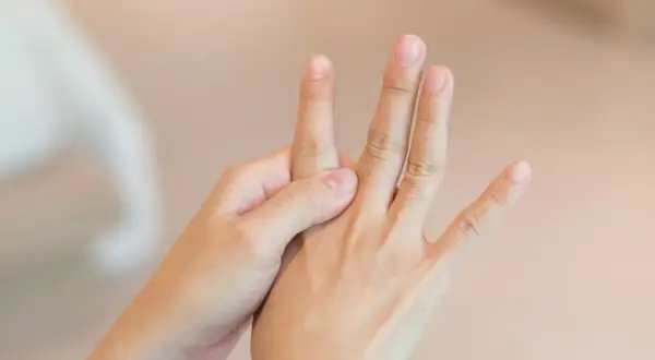 Mani che si massaggiano per alleviare i sintomi della neuropatia alle mani.