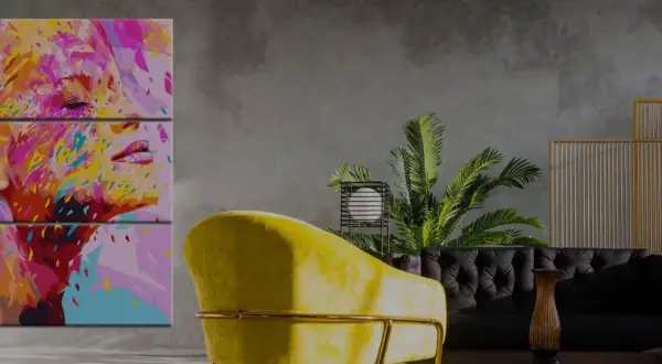 Abstraktes Porträt einer Frau in leuchtenden Farben auf einem Triptychon-Bild, das in einem modernen Wohnzimmer hängt.
