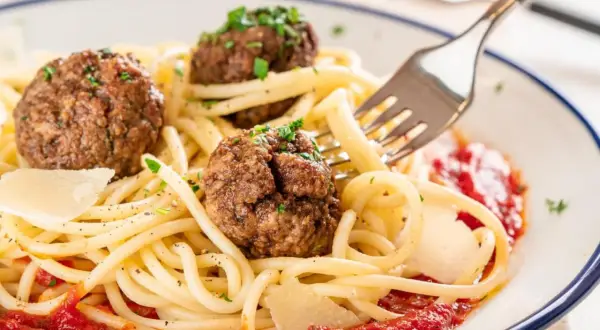 Spaghetti mit drei herzhaften polpetta deutsch, garniert mit Parmesan und Petersilie, serviert mit Tomatensauce.