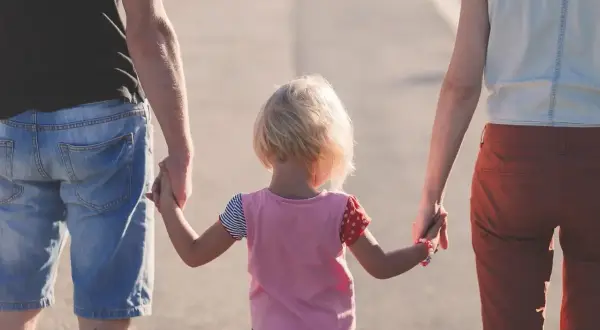 Famiglia cammina mano nella mano. Il congedo parentale preavviso 48 ore permette momenti preziosi.