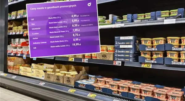 Fioletowa plansza z cenami masła w promocji na tle półek sklepowych z produktami.
