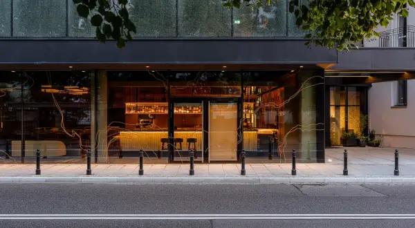 Elegancki bar i restauracja w hotelu Nobu Warszawa, widoczne przez duże okna od strony ulicy.