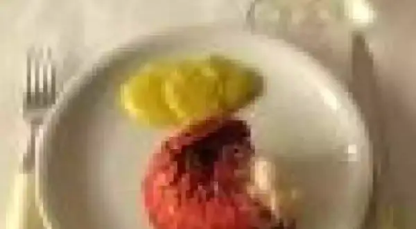 Une langouste rouge sur une assiette blanche avec des tranches de citron. On se demande : peut on manger les œufs de langouste ?